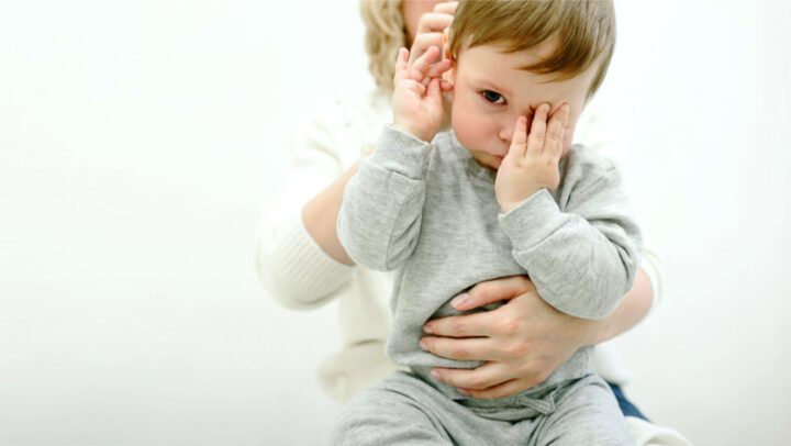 Imagem de criança em tratamento na Consulta de Fisioterapia (ou cinesiterapia) Respiratória com a Fisioterapeuta atrás
