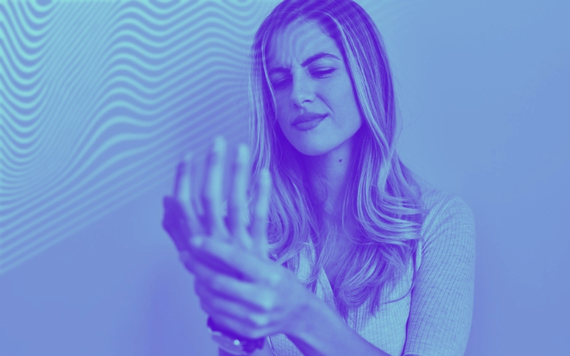 blog-rigidez-matinal-1 imagem de mulher segurando a mão com expressão de dor